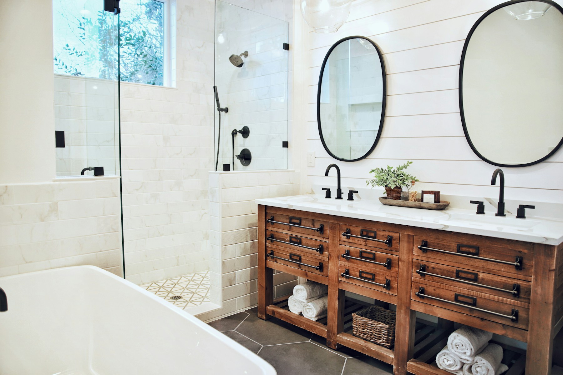 Warm transitional bathroom with a wood vanity and tiled shower